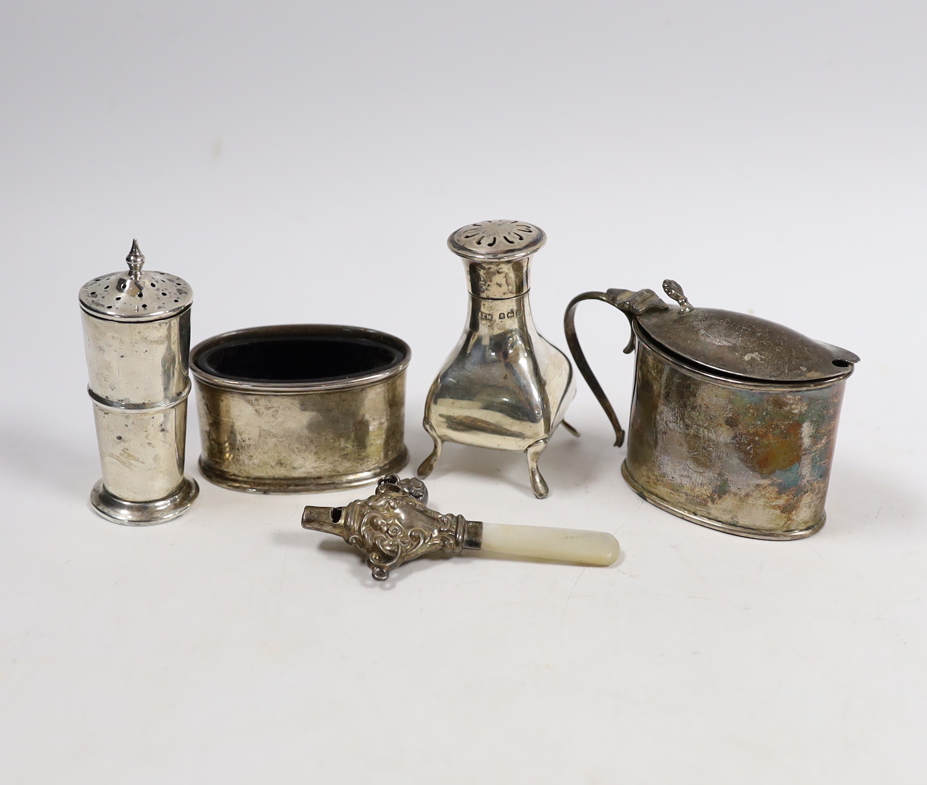 Four assorted silver cruets and a silver child's rattle.
